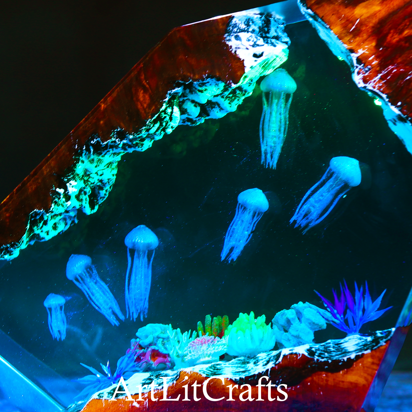 close up view of jellyfish and colorful coral reef inside resin lamp with 'AquaLitCrafts' branding.