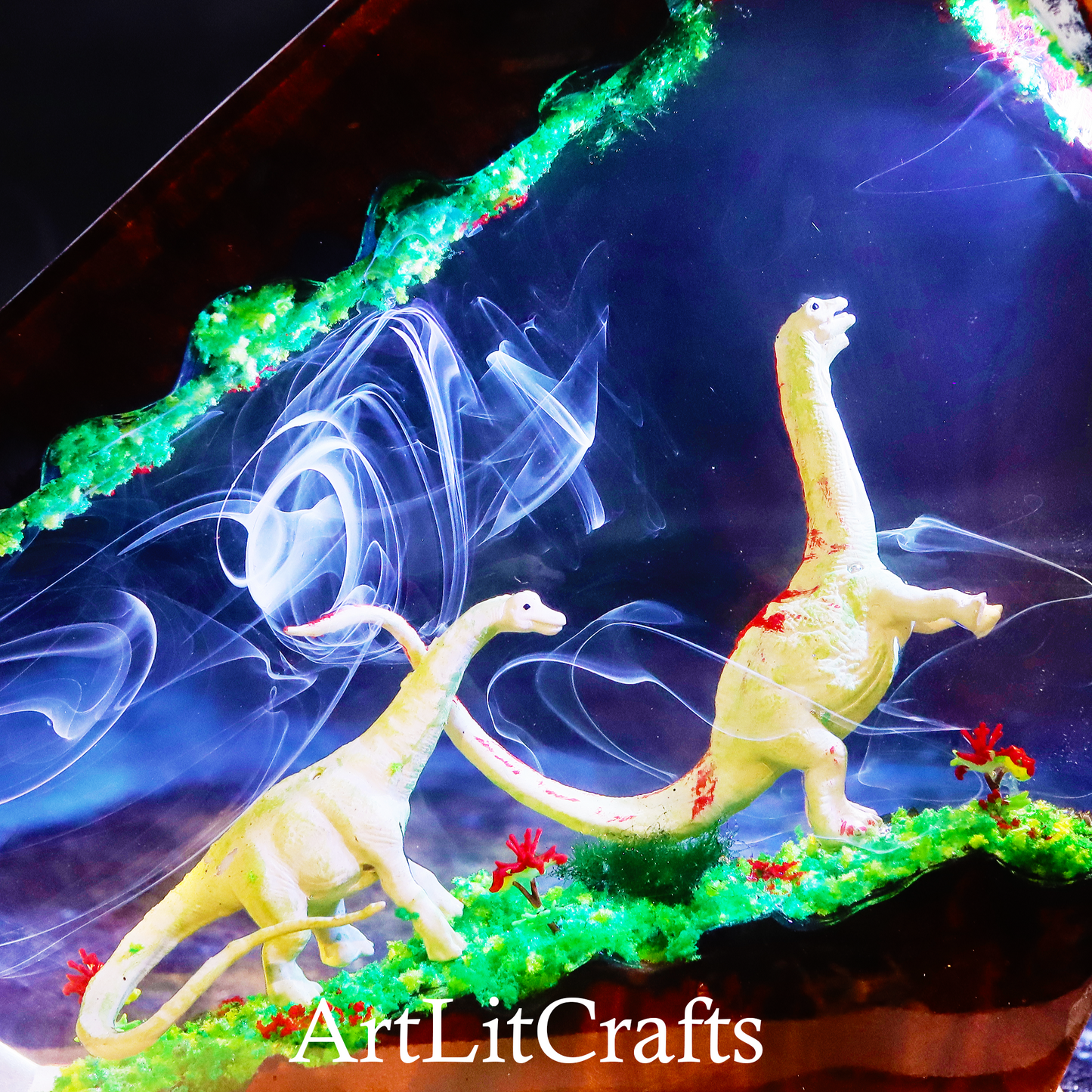 Two dinosaur figurines on a decorative base with smoke effects and 'ArtLitCrafts' branding.