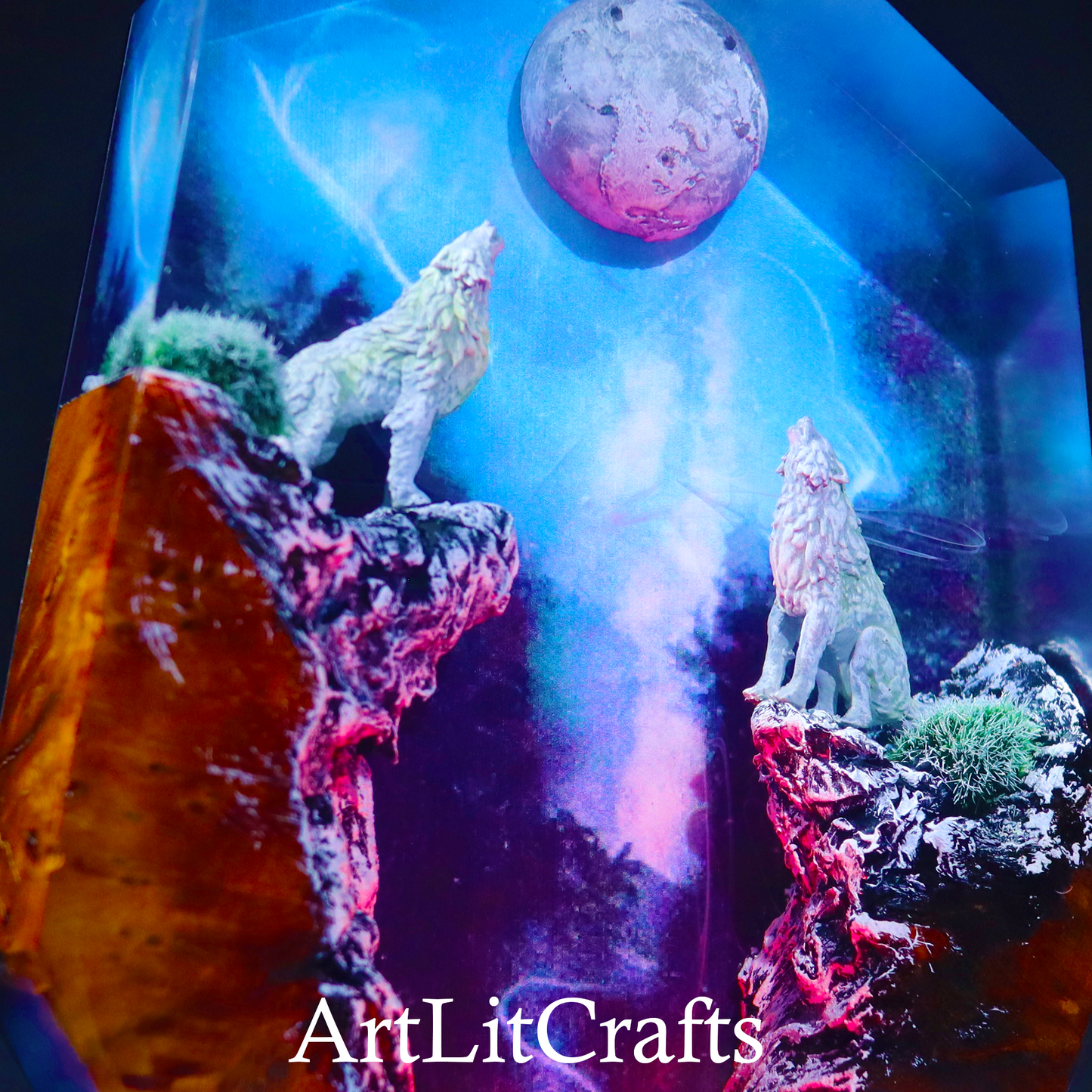 close up of detailed wolf figures standing on rocky cliffs inside resin lamp, branded 'ArtLitCrafts'.