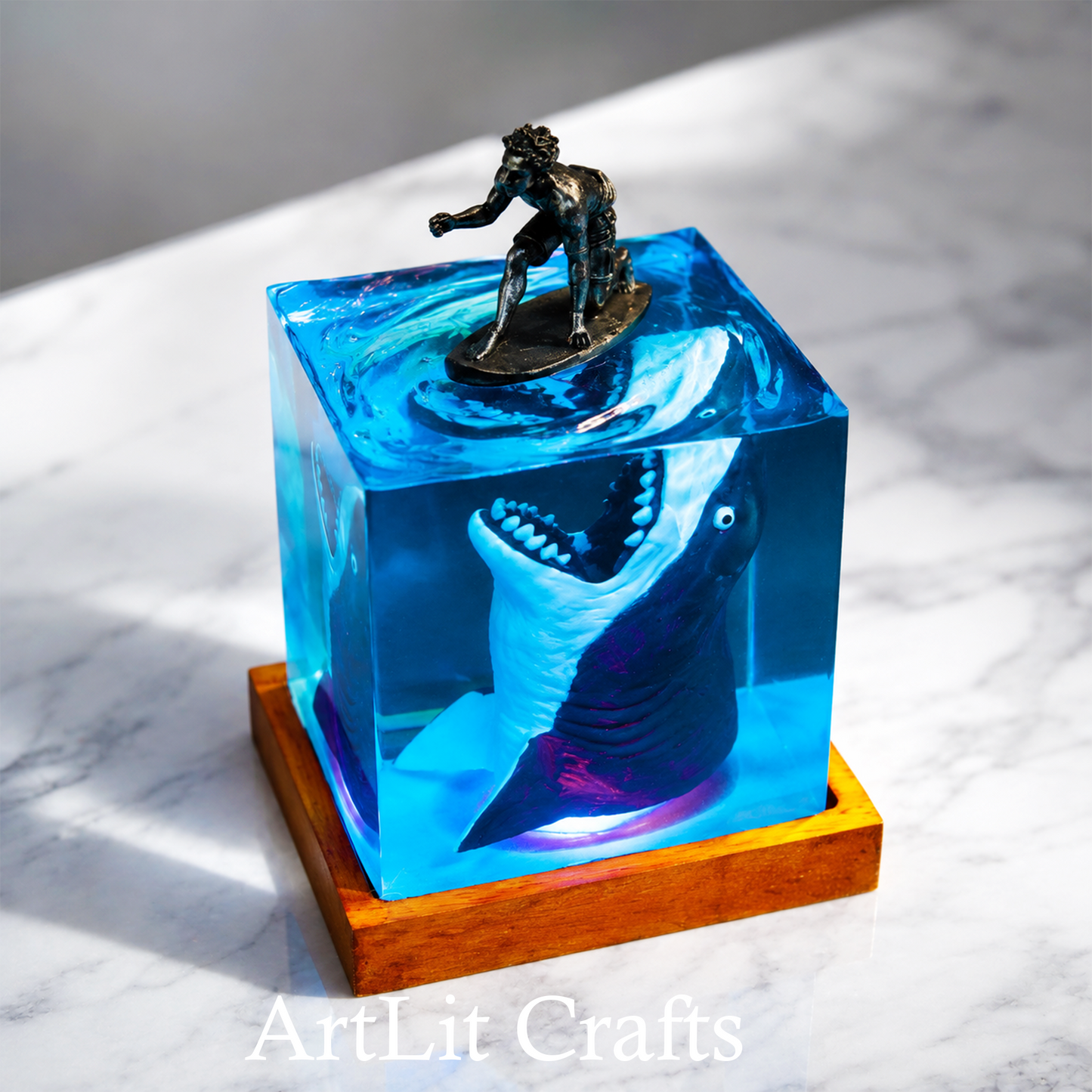 Blue resin sculpture of a shark and person on a wooden base, with 'ArtLit Crafts' branding.