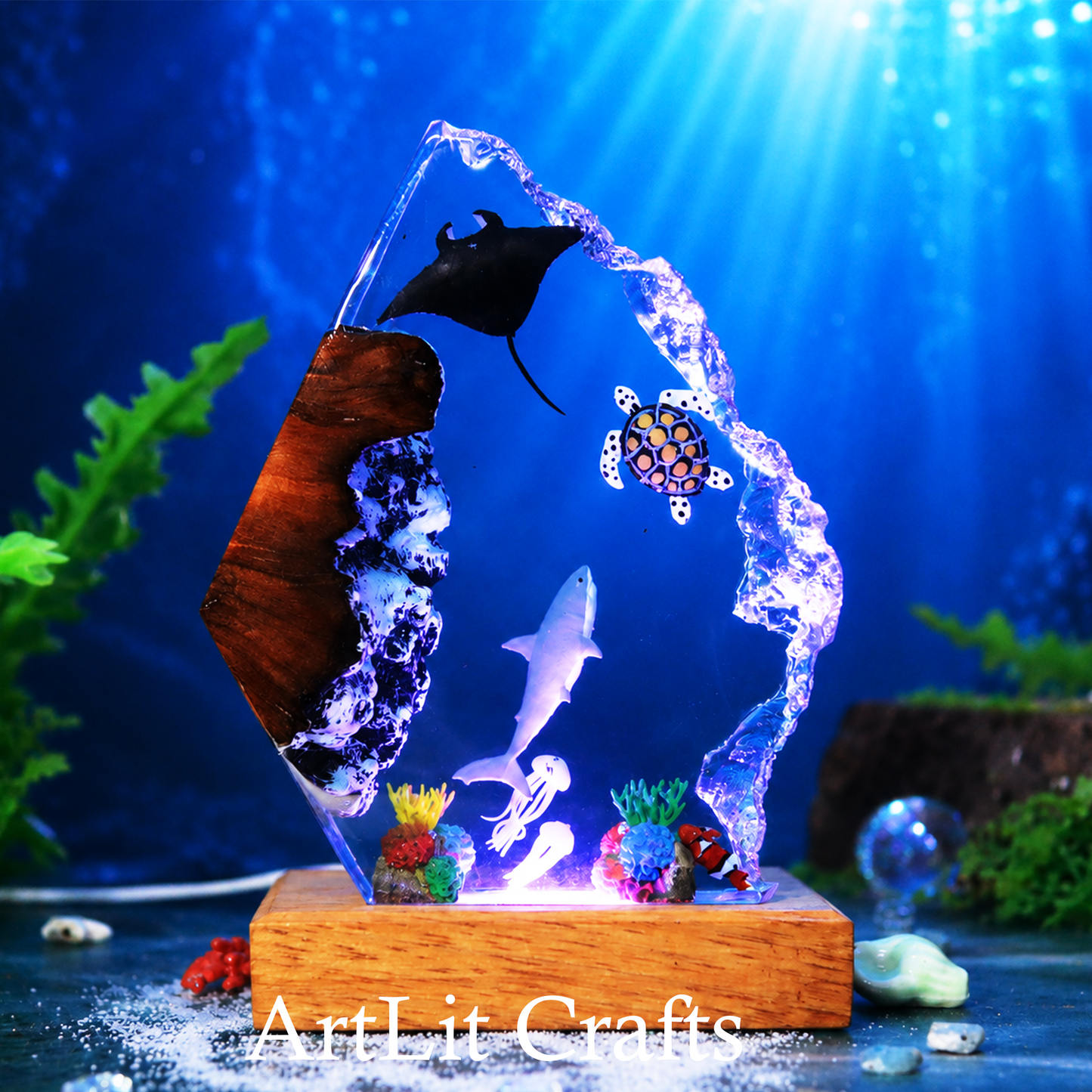 Decorative underwater scene with fish and coral on a wooden base, illuminated by blue light.