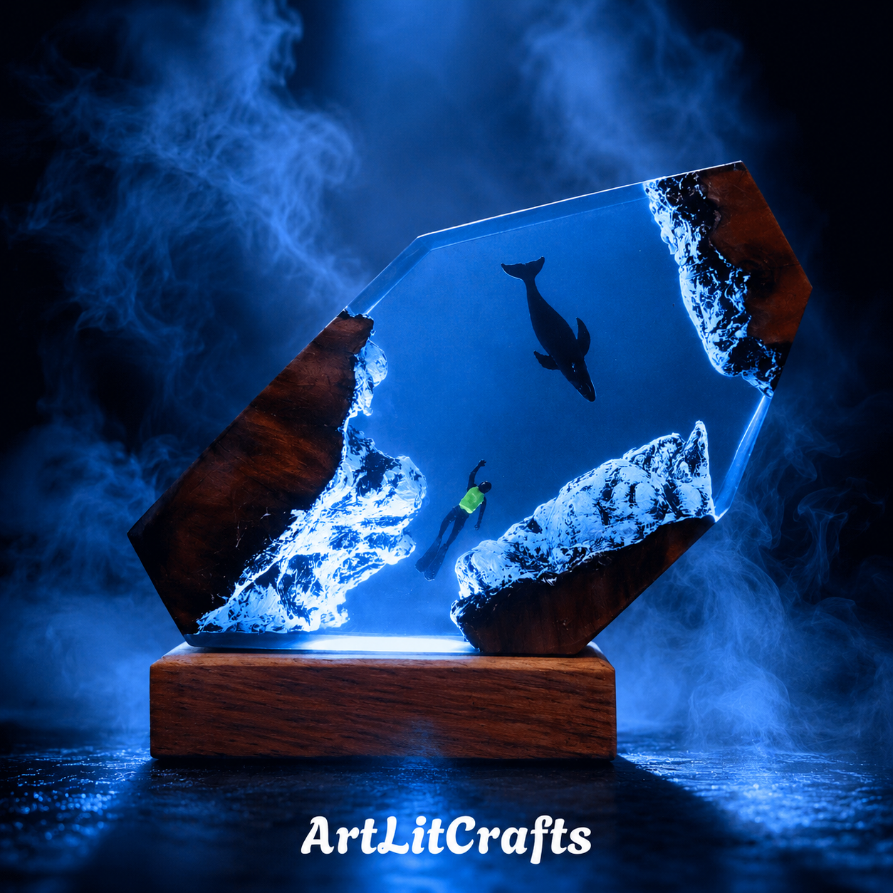 Glass sculpture with wooden base featuring a diver and whale, illuminated by blue light, with 'ArtLitCrafts' branding.