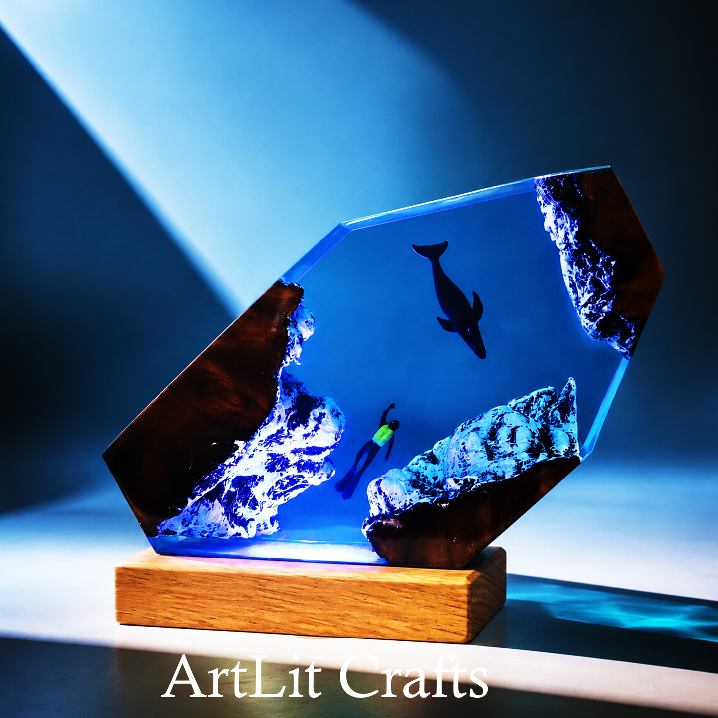 Glass sculpture with underwater scene on a wooden base, illuminated by blue light, branded 'ArtLit Crafts'.